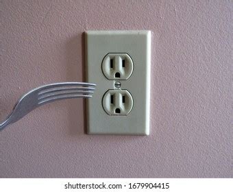 putting plastic fork in electrical outlet